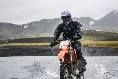 人骑土摩托车在白天期间水体
